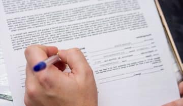 hand with pen and form