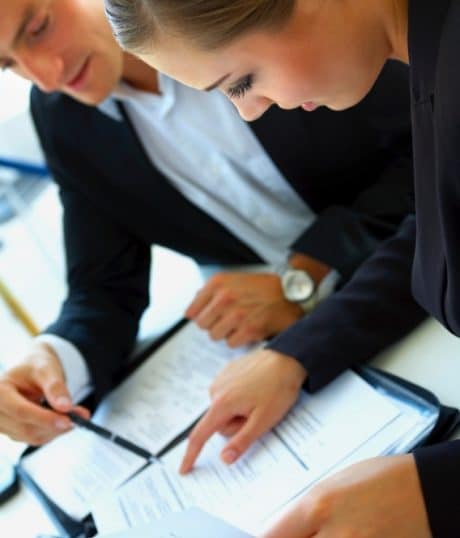 Businesswoman and man reviewing documents, about the HR Team