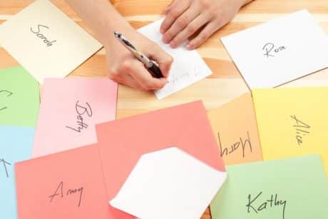 Close up of hand with pen addressing cards